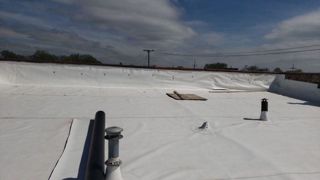 TPO rubber roofing material being installed